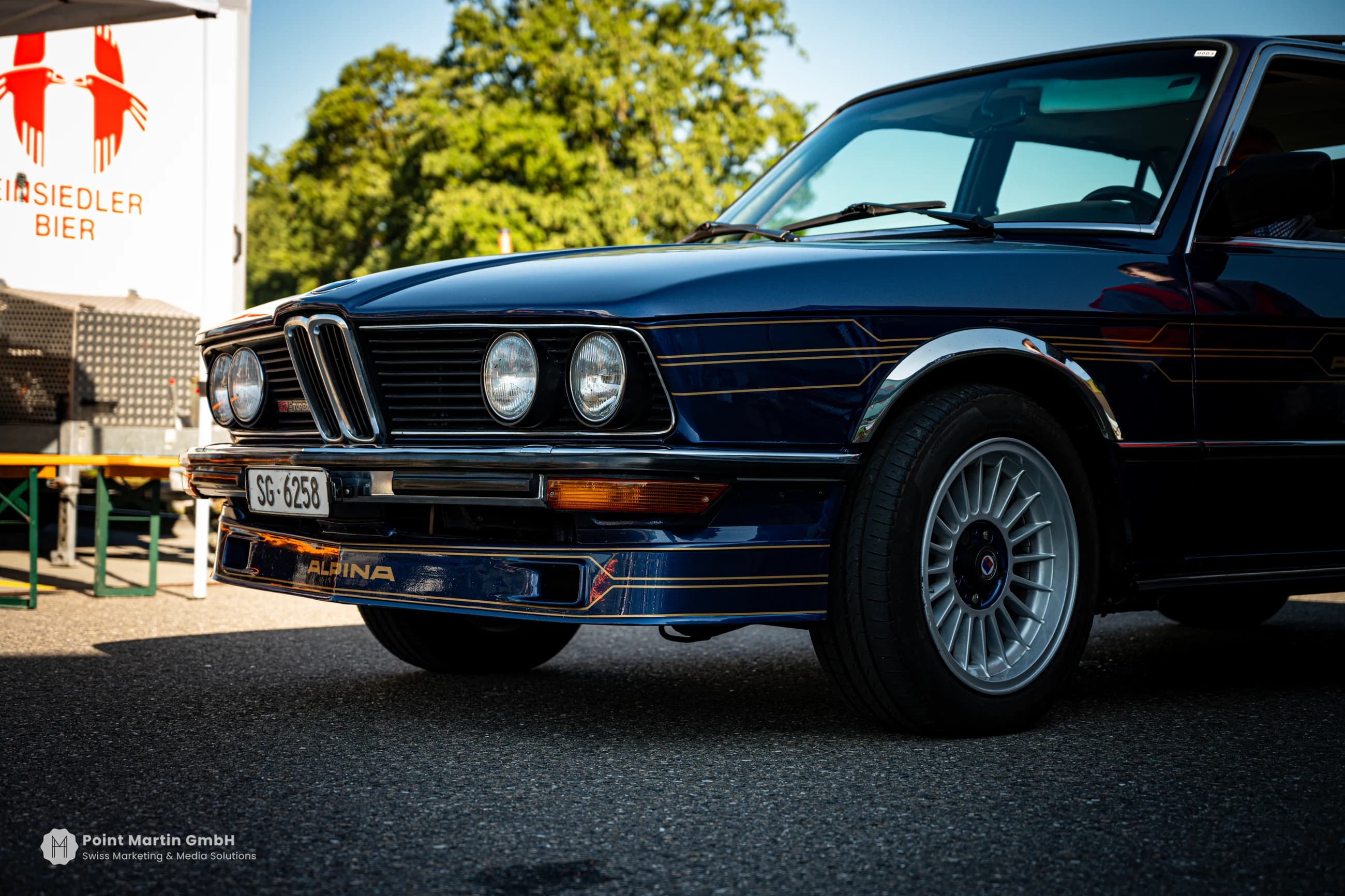Dark blue classic BMW Alpina with gold pinstripes and multi-spoke wheels